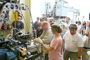  Scientists gather around Alvin&rsquo;s basket, eager to see the samples that have been collected. 