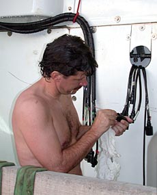 Alvin Pilot BLee Williams uses a cotton swab to make sure electrical connectors on the submersible are completely dry. 