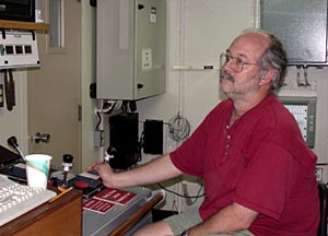  Bob Collier monitors the track of the CTD towed with a long wire near the seafloor and uses a joystick to control the winch that winds the wire up and down.