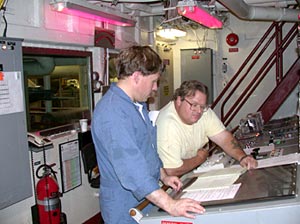  Chief Engineer Kevin Fisk and Third Engineer Phil Treadwell review the never-ending list of tasks to be done to keep Atlantis&rsquo; heating, cooling, and plumbing systems, as well as its engines, operating smoothly.