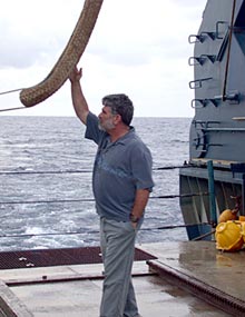 After the final dive of the cruise, Captain George Silva examines the line that lifts Alvin in and out of the water for wear and tear. 