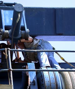  While the ship is at anchor in port, Third Engineer Phil Treadwell takes the opportunity to grease the A-frame that launches and recovers Alvin.