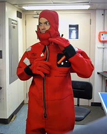 Dive and Discover writer Joe Appel, after yanking on his “gumby suit,” an immersion suit capable of keeping someone warm and afloat for some time, depending on conditions. Everyone on board stores one of these suits in his or her berth.  