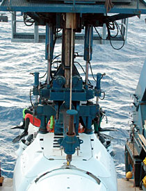 This is Alvin, attached to the A-frame that lowers it. You can see two swimmers on either side of the sub. Usually, this position means that Alvin is minutes away from being dropped. But it was not to be. The attempt to fix the Avon's steering delayed Alvin's launch just long enough for strong gusts to come up. Those gusts, and the higher swells they brought, forced the dive to be postponed. 