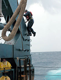 First Assistant Engineer Gary McGrath climbs the "A-frame" that is used for putting Alvin in the water and taking it out. He was performing some routine maintenance, despite the fact that weather conditions weren't routine. Keeping equipment running smoothly is necessary no matter what the weather.