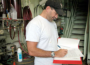 Alvin Pilot Bruce Strickrott fills out documentation on the sub's window maintenance. Every element of maintenance on Alvin is documented in detail. The window check alone requires 20 pages. 