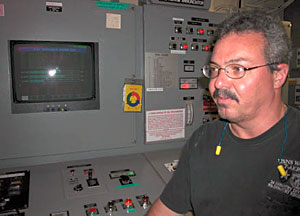 1st Assistant Engineer Gary McGrath, at the engine console in the ship's engine room. With rough seas and strong headwinds, McGrath said, the ship was running at its highest power since the trip began.  
