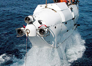 This is what happens when you lift a 37,000-pound submarine out of the water. Water spills out from beneath the white exterior cover.  