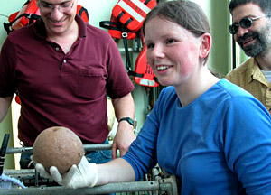 Alvin technician Noel Masias drops a transponder off the stern deck of R/V Atlantis as weather conditions improved in the late afternoon. 
