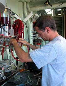 Alvin pilot-in-training Gavin Eppard working on the sub's hydraulics system. Hydraulic fluid is a key component of many of Alvin's systems. 