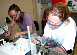 Scientists Selene Eltgroth, left, and Laura Robinson, hard at work scrubbing corals in the ship's "wet lab." The science group works in four-hour shifts cleaning samples. They're smiling, but it's a grueling job -- the downside to our success in gathering Desmophyllum cristagalli. 