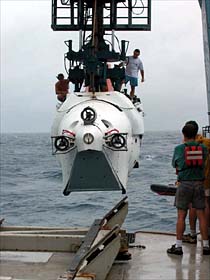 Alvin about to be lowered from the A-frame. At this point in the launch, the A-frame operator must time the drop with the ocean's swells, in order to keep the sub clear of the ship and its passengers safe. 