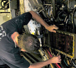 Alvin pilot-in-training Gavin Eppard works on the sub&rsquo;s starboard junction box, where many electrical wires join up. On the way into Bermuda, the Alvin crew began work on the semi-annual maintenance overhaul.  