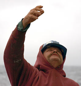  Wayne Bailey, the ship&rsquo;s bosun, waits to receive a line from a crane that will lift the Alvin recovery boat into the water. A bosun serves as the deck foreman.