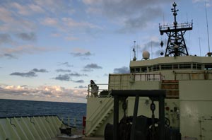 Vicki Lynn Ferrini enjoys the evening from a deck near the ship&rsquo;s bow. On this cruise she is developing seafloor maps as a guest investigator from the Woods Hole Oceanographic Institution.