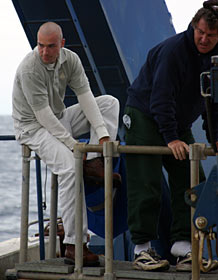 Electrical Technician Anthony Berry (left) slips back into his shoes after his 11th trip to the seafloor as an Alvin pilot in training, or PIT. Expedition Leader J. Patrick Hickey, who is overseeing Anthony’s training, joined him on the dive.Electrical Technician Anthony Berry (left) slips back into his shoes after his 11th trip to the seafloor as an Alvin pilot in training, or PIT. Expedition Leader J. Patrick Hickey, who is overseeing Anthony’s training, joined him on the dive.