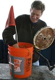 Ben Larson, a graduate student in marine chemistry at the University of Washington, examines defunct science equipment and old markers collected Tuesday in a clean up effort at the Main Endeavour hydrothermal vent field.