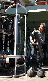 Kazumi Baba, a shipboard sciences services group technician, makes adjustments to bottles used on the CTD, an instrument that measures water conductivity (an indicator of how salty it is), temperature, and depth in the ocean. 