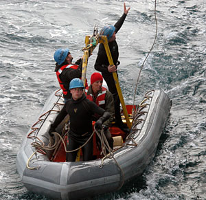 After Alvin is deployed, the recovery boat returns to Atlantis. Preparing lines that will bring the boat to the deck are Mechanical Technician Gavin Eppard (front), Seaman Kevin Threadgold (red hat), Seaman Ed Popowitz, and Sean McPeak, an electrical technician with the Alvin group. (Photo by Mitch Elend) 