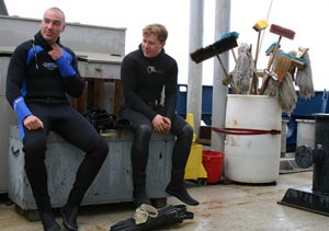 Swimmers Anthony Berry (left) and Sean McPeak, both with the Alvin group, wait on he ship’s fantail before the Alvin deployment.