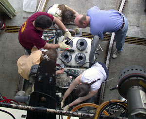 Scientists gather around Alvin&rsquo;s basket to prepare and secure instruments, probes, and collection baskets. Alvin carried the equipment to the seafloor during the first dive of this expedition.
