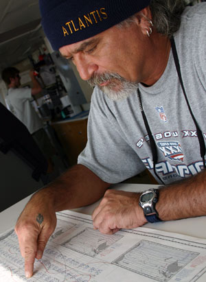 Captain George Silva refers to a pilot chart of the south Pacific. The chart offers weather information recorded and averaged over many years and specific to particular regions. (Photo by Amy Nevala)