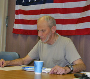 Ray Heimberger, the communications and electrical technician on Atlantis, catches up on news faxed to the ship. Ray, a veteran of the U.S. Marines who flew with a helicopter squadron for four years until 1964, said he was proud to see the American flag hanging in the galley over Memorial Day weekend. (Photo by Amy Nevala)
