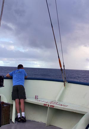 1. Alvin pilot in training Mark Spear enjoys morning coffee on the ship�s bow. Incoming rain later soaked the decks. (Photo by Amy Nevala)