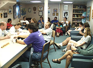 Members of the science party meet for the last time in the ship’s library to discuss the results of the dives and to plan the follow- up research on shore. 