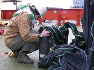 Lena Von Harbou, a graduate student from the Alfred Wegner Institute in Germany, begins to attach the net to one of the �cod ends,� or collecting chambers of the MOCNESS. (Photo by K. Madin)