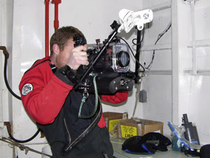 Look Ma�two hands: Jeff Mercer gives the underwater video camera a final inspection before taking it to the waiting dive boat. (Photo K. Madin, WHOI) 