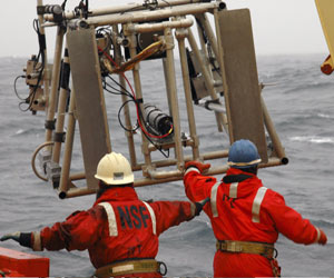 Byron Pedler (right) reaches for the net�s frame as it is pulled over the stern.  
