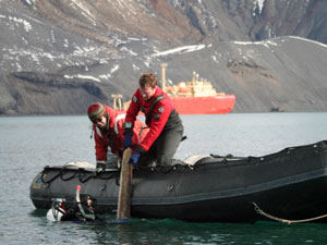 Brennan Phillips (in the water) lifts a whale rib left by earlier twentieth-century whalers and found on the bottom of Whaler’s Bay up to Jeff Mercer and Jamee Johnson in the Zodiac. Trent University graduate student Brenna McLeod collected small shavings of bone for later DNA analysis. (Photo by Lens Von Harbou, Alfred Wegener Institute)