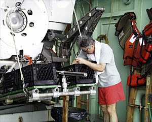 Dan picks volcanic glass out of the basket after retrieving the sample. It is important to clean the basket after each dive so pieces of rock taken from different places do not get mixed up. 
