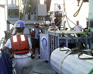 Patrick Hennessy (back to camera) Bosun Jerry Graham, and Dave Sims (in background) launch the Towed Camera Sled. 