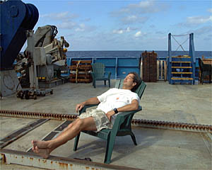 Patrick Hennessy takes a nap on the fantail after his watch on the Bridge. Crew work 4 hours on watch and then have 4 hours to relax and get some sleep.