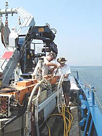 PJ Bernard (left) and Craig Elder prepare the DSL-120 sonar for its first deployment. The sonar “fish” is towed 100 meters above the seafloor. It produces sidescan sonar maps that give us very precise images of the seafloor’s structure and topography along swaths that are about 1,000 meters wide.