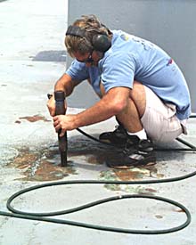 Chief Mate Dave Murline removes rusted paint on the ship’s bow with a needle gun. The bare metal exposed by the needle gun will be primed and painted later. Daily maintenance is required to keep Melville in top working order.