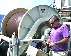 PJ Bernard operates the traction winch that is used to lower the DSL-120 sidescan sonar down to the seafloor. The large storage drum of wire behind him holds about 11,000 meters of fiber optic cable!