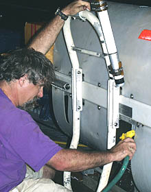 PJ Bernard washes the DSL-120 sonar vehicle with fresh water after it was recovered last night. Seawater is very corrosive and must be washed off all the vehicle components so that the metal and rubber connectors and fasteners do not degrade.