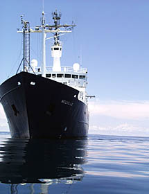You can get a feeling for how calm the seas are, almost glassy, as the rescue boat circumnavigates the ship. R/V Melville strikes a stately pose in the tropical Pacific. 
