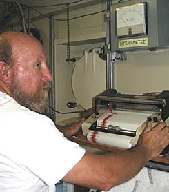 Ron Comer adjusts the recorder for the “Bite-O-Meter”, or tensiometer. This device tells us how much tension is on the dredge wire. When the dredge is being dragged across the seafloor, “bites”, or increased tension, on the meter indicates that the dredge might be breaking off pieces of lava. We like to see many “bites” while dredging! The recorder under the “Bite-O-Meter” plots the “bites” during each dredging operation.