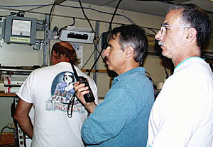 Mike Perfit (right) and Dan Fornari (middle) stand watch during dredging operations this evening. Dan is using the walkie-talkie to talk with Tom Crook and Jeff Keeler who are navigating the ship from the Control Van. Ron Comer (back to camera) is setting up the “Bite-O-Meter” (see next slide).