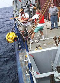Randy Dickau (left) and Ron Comer (middle) haul in one of the transponders so that Tom Crook (right) can get it ready for the next deployment. Today, we recovered all three transponders that we have been using to navigate on the seafloor.