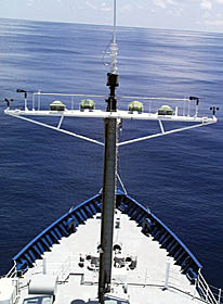 A view towards the bow of R/V Melville from the Crows Nest. You can see how calm the ocean is. Even though it is calm, the ship is still rolling gently in the long, broad swells. At the top of the photo, the sea surface looks tilted -- it isn’t, it is the ship rolling! Take a protractor and measure the angle between the horizon and a horizontal line across the top of the photo -- that will tell you how much the ship is rolling.