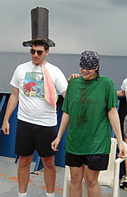 The Royal Public Defender (Dan Scheirer) leads Julia Getsiv away from the Royal Barber’s chair to face King Neptune and the court.