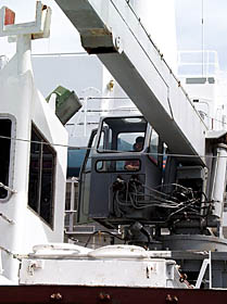 Randy Dickau, one of the Scripps Resident Technicians, operates the crane to move heavy equipment around the fantail of R/V Melville.