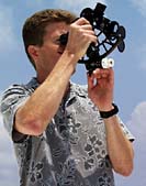 Captain Buck uses a sextant on the flying bridge of R/V Melville.