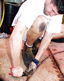 Greasy hands and knees are part of a day’s work for DSOG tech Pete Collins. The DSOG team and Knorr crew are working sun-up to sunset to assemble the deep submergence vehicles.  
