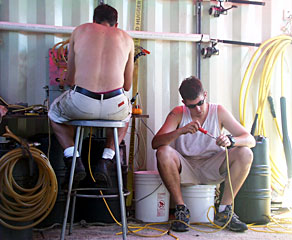 DSOG team members Fran Taylor (left) and Peter Collins change the oil in one of the ROV Jason’s junction boxes. “On submersibles like Jason, all the electrical wires and junction boxes are full of oil to compensate for the pressure at 10,000 feet,” explains Fran. “So whenever you work on Jason’s electronics, you have to take the oil out and then put it back in.”